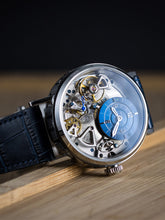 Skeleton watch with blue leather strap on a desk