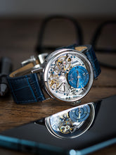 Skeleton watch with blue leather strap on a desk